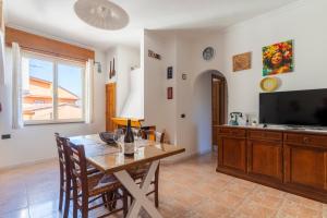 a dining room with a table and a tv at Sa omu de sa palgia in Jerzu