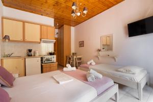 two beds in a room with a kitchen at Nontas Homes 37 in Kalamitsi