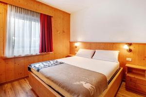 a bedroom with a large bed with a window at Tra-monti e Mare Bormio in Valdidentro