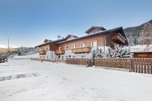 a house with a fence in the snow at Tra-monti e Mare Bormio in Valdidentro