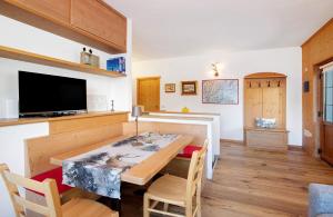 a dining room with a table and a tv at Tra-monti e Mare Bormio in Valdidentro