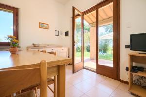 a dining room with a table and a television at Mare Etrusco Villetta D2 in Populonia