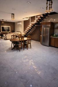 a dining room with a table and a kitchen and stairs at Devon Chalet in Amman