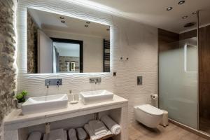 a bathroom with two sinks and a toilet and a mirror at Villa Afroditi - Sfinari in Áyios Nikólaos +31 photos