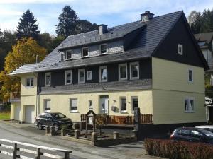 a large house with a black roof at Fewo In Schustes in Willingen