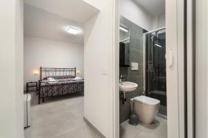 a bathroom with a toilet and a sink and a bed at Villa Giovia in Guspini