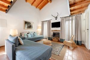 a living room with a blue bed and a couch at Daniel Cottage - Portimão in Portimão