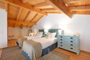 two beds in a room with wooden ceilings at Daniel Cottage - Portimão in Portimão +16 photos