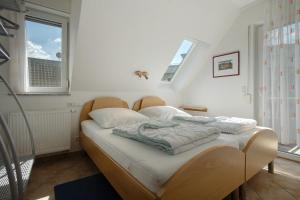 a bedroom with a bed with white sheets and two windows at Fewo 20 Röbel Müritzblickhaus in Röbel