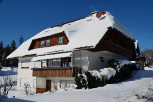 a house with snow on the roof at Gästehaus Waldhüsle in Friedenweiler