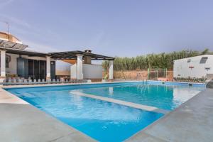 a large swimming pool with blue water at Finca El Abuelo in Lepe
