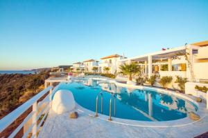 a large swimming pool next to a building at Kaladi Rock Avlemonas in Avlemonas