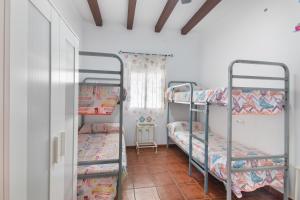 a room with three bunk beds and a window at Finca El Abuelo in Lepe +20 photos