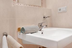 a bathroom with a white sink and a mirror at Appartement Egart 1 in Resia +25 photos