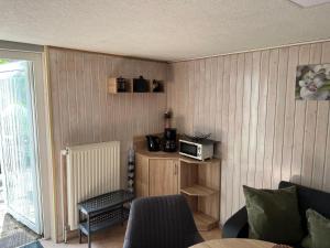 a living room with a microwave on a wooden wall at Bungalow in Gager