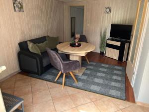 a living room with a couch and a table at Bungalow in Gager