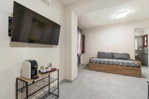 a bedroom with a bed and a flat screen tv on the wall at Villa Giovia in Guspini