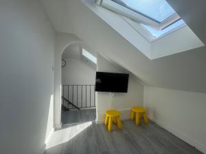 two yellow stools in a room with a skylight at M und S - Landidyll am Weiher in Harsum