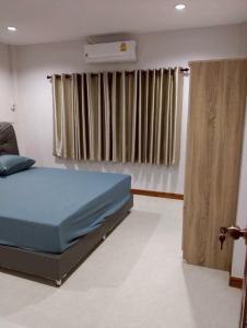 a bedroom with a bed and a air conditioner at บ้านกรรณิการ์ in Chiang Mai