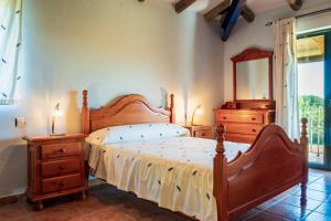 ein Schlafzimmer mit einem Bett, zwei Kommoden und einem Spiegel in der Unterkunft Amaltea in Candeleda