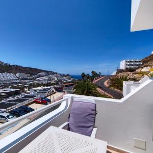 a balcony with a chair and a view of the ocean at Apartamento Joya in Puerto Rico de Gran Canaria