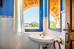 ein Badezimmer mit Waschbecken und Fenster in der Unterkunft Amaltea in Candeleda + 33 Fotos