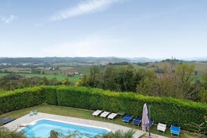 a swimming pool with chairs and umbrellas in a yard at Tenuta Paradiso in Portacomaro