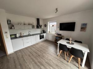 a kitchen with a table and chairs and a television at Ferienwohnung Charly in Carolinensiel