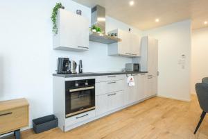 a kitchen with white cabinets and a stove at Ferienwohnung Bergblick in Kappelrodeck