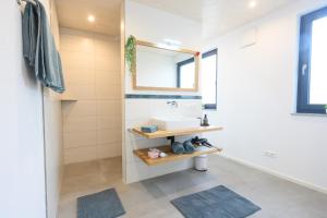 a bathroom with a sink and a mirror at Ferienwohnung Bergblick in Kappelrodeck +21 photos