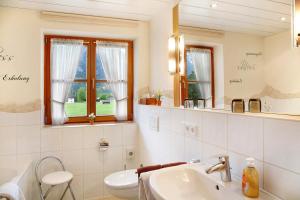 a white bathroom with a sink and a mirror at Landhaus Bergkulisse in Wallgau