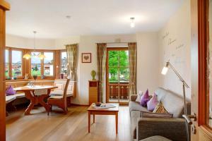 a living room with a couch and a table at Landhaus Bergkulisse in Wallgau
