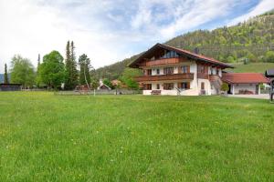a house in a field with a green field at Landhaus Bergkulisse in Wallgau