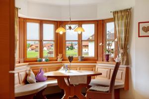a dining room with a table and some windows at Landhaus Bergkulisse in Wallgau +16 photos