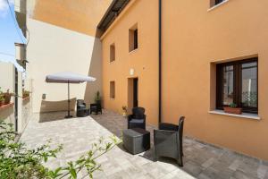 a patio with chairs and an umbrella next to a building at Villa Giovia in Guspini