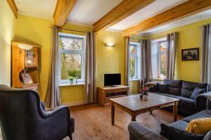 a living room with a couch and a table at Gulfhof Oldersum Erdgeschoss in Moormerland
