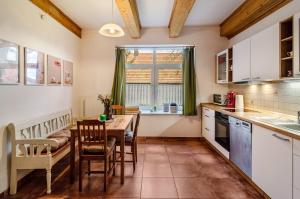 a kitchen with a table and a table and chairs at Gulfhof Oldersum Erdgeschoss in Moormerland