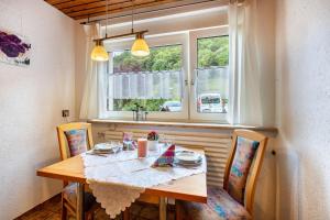 a dining room table with two chairs and a window at Haus Strohmeier in Brandenberg