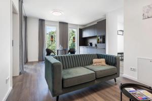 a living room with a green couch and a kitchen at Egge Resort 7a mit Whirpool u Sauna in Altenbeken