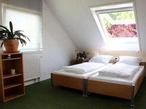 two beds in a room with a window at Ferienwohnung auf der Baar in Bad Dürrheim