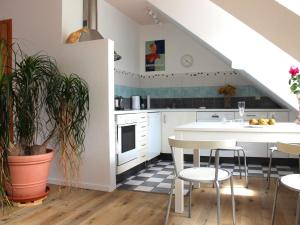 a kitchen with white cabinets and a table and chairs at Ferienwohnung auf der Baar in Bad Dürrheim