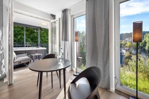a living room with a table and chairs and a large window at Egge Resort 7a mit Whirpool u Sauna in Altenbeken