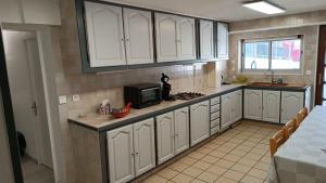 a kitchen with white cabinets and a microwave at Chez Léa in Bourges