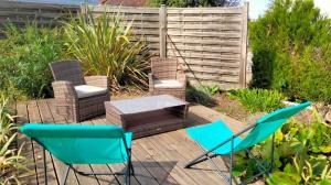 a patio with chairs and a table and a fence at Chez Léa in Bourges