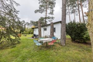 a table and chairs in a yard next to trees at Ferienhäuschen Wils in Borkheide