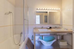 a bathroom with a tub and a sink at Le Lion d'Or in Lagorce +26 photos