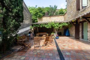 a patio with chairs and tables in an old building at Le Lion d'Or in Lagorce