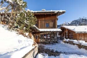 a log cabin in the snow with tables and chairs at Coeur de neige 1724 in Le Grand-Bornand