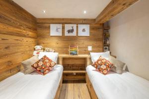 two beds in a room with wooden walls at Coeur de neige 1724 in Le Grand-Bornand