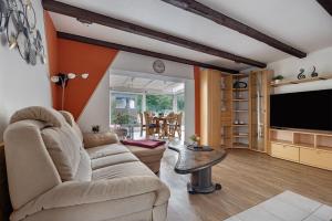a living room with a couch and a flat screen tv at Ferienhaus In Oerrel Mit Pool in Munster